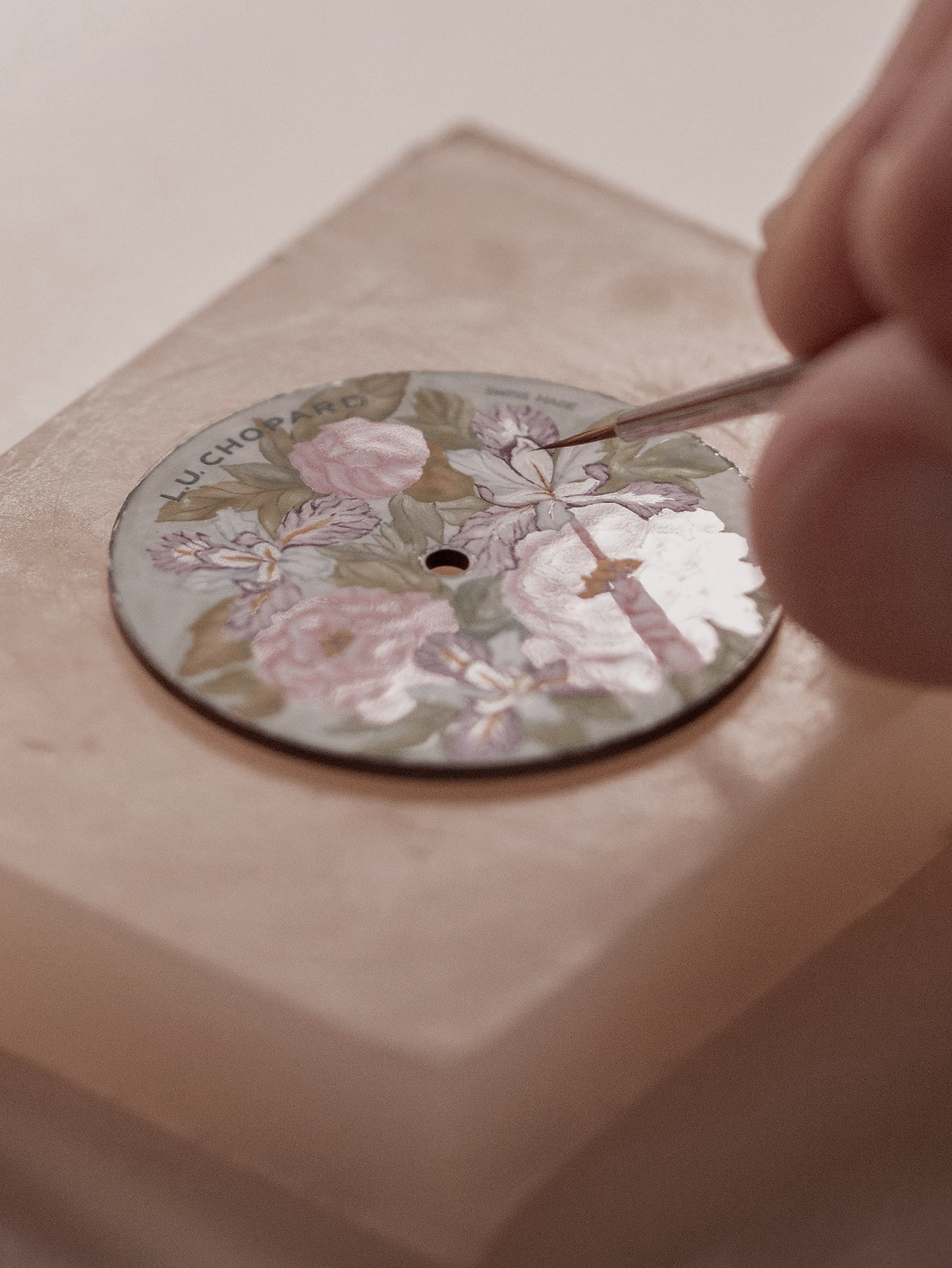 Un artisan Chopard peignant le cadran d'une montre de luxe